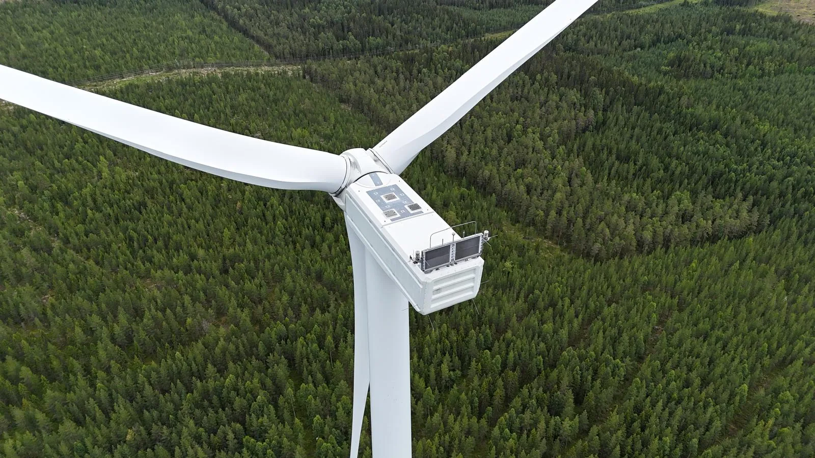 Flygbild av vindkraftverk i svenskt skogslandskap